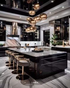 a modern kitchen with black cabinets and marble counter tops, gold pendant lights hanging from the ceiling