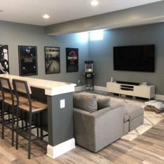 a living room filled with furniture and a flat screen tv mounted to the side of a wall