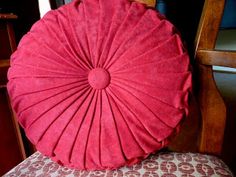 a red pillow sitting on top of a wooden chair