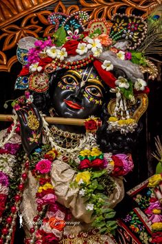 an idol with flowers and feathers on it's head