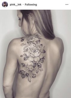 the back of a woman's body with flowers tattooed on her upper and lower back