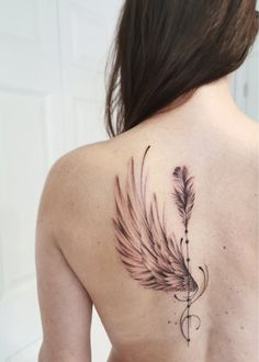 the back of a woman's shoulder with a feather tattoo on it