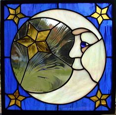 a close up of a stained glass window with a moon and stars in the background