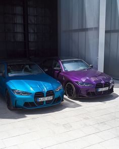 two cars parked next to each other in front of a building