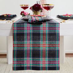 the table is set with black, red and green plaid napkins on top of it