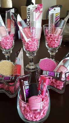 three clear vases filled with pink items on top of a table