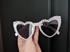 someone is holding up their sunglasses with the words wife of the party on them and they are wearing heart shaped glasses