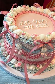 there is a cake that has been decorated with shells and pink ribbons on the table