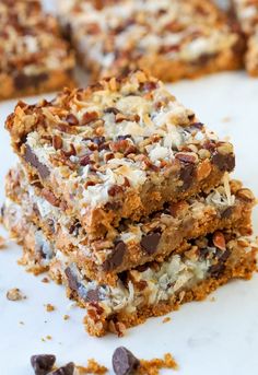 chocolate chip cookie bars stacked on top of each other with coconut flakes all over them