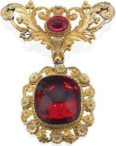 A 19th century garnet brooch, circa 1830 The large carbuncle garnet within a foliate tri-coloured gold surround suspended from a scrolling foliate surmount with central oval cabochon-cut garnet, closed back settings, length 55mm: Historical Jewellery, Garnet Jewelry, Victorian Jewelry, Vintage Jewels, Fantasy Jewelry, Gems Jewelry, Oval Cabochon, High Jewelry