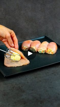 a person is cutting up some food on a black plate