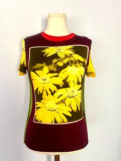 Jean Paul Gaultier Maille knit top with silkscreen photographic print of yellow flowers on a very stretchy and silky knit, with flutter seams and laser cut hem.  with openwork from the early 2000s. Signature back tab. Collectors piece. In excellent vintage condition. Marked a size Medium, but this very stretchy knit can fit several sizes. Model is a Small and mannequin is a smallish medium. - Made in Italy by Fuzzi - Brand: Jean Paul Gaultier Maille MEASUREMENTS - taken flat, across. See last pi Flower Knit, Daisy Print, Paul Gaultier, Early 2000s, Jean Paul, Jean Paul Gaultier, Photo Print, Yellow Flowers, Womens Clothing Tops