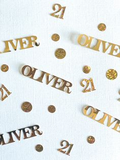 gold and silver confetti cut out into the shape of numbers on a white surface