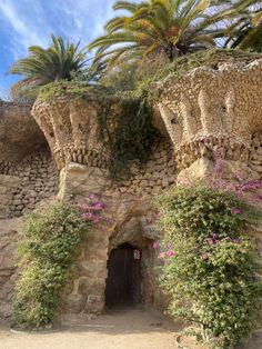 an old stone building with plants growing on it's sides and a door in the middle