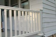 a person standing on the front porch of a house with white railing and handrails