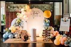 balloons and decorations are on display at the baby shower party in an office building with wooden floors