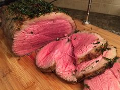 sliced up meat sitting on top of a wooden cutting board