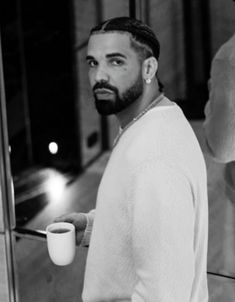 a man with a beard holding a coffee cup