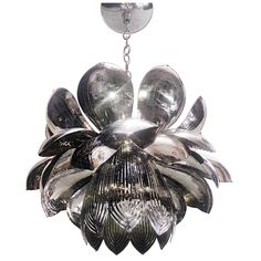 a chandelier hanging from a chain with shiny glass petals on it's center