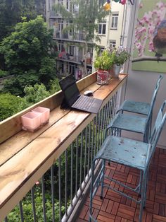 a laptop computer sitting on top of a wooden table next to a blue metal chair