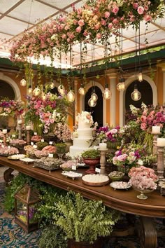 a long table covered in lots of flowers and cake sitting on it's side