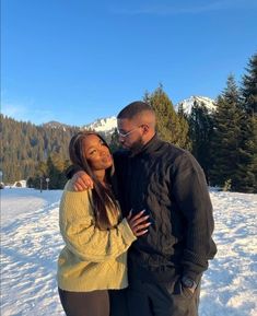 a man and woman are standing in the snow