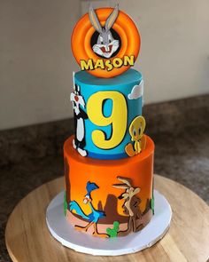 a three tiered cake with cartoon characters on it