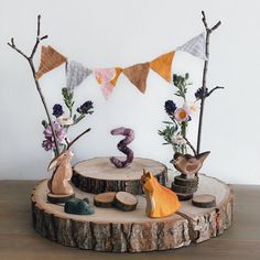 a wooden table topped with vases filled with flowers and animals on top of it