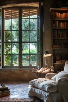 a living room filled with furniture next to a large window covered in bookshelves