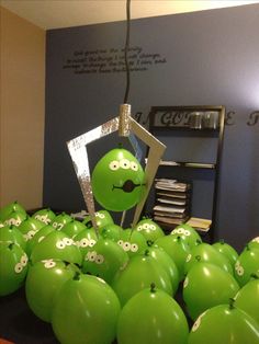 some green apples with faces drawn on them in front of a bunch of other green apples