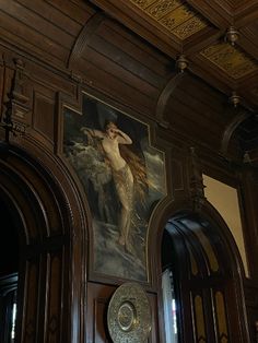 an ornate painting on the side of a wooden door in a room with arched doorways