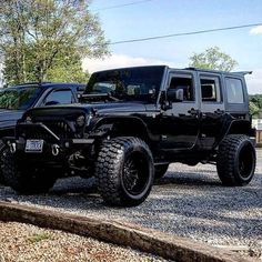 two black jeeps parked next to each other