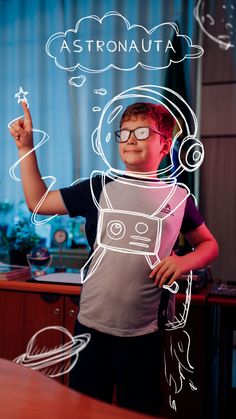 a young boy wearing glasses standing in front of a drawing of an astrological device