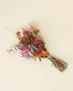 a bunch of dried flowers sitting on top of a white table next to each other