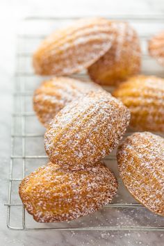 powdered sugar covered donuts on a cooling rack