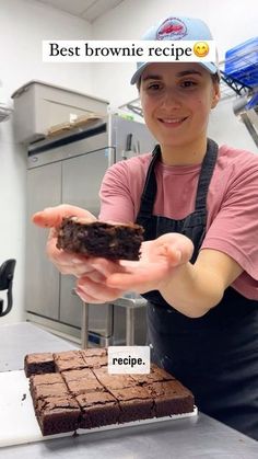 a woman holding a piece of brownie in her hands