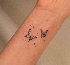 two butterflies on the wrist tattoo design for women and girls, with stars in the background