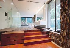 the interior of a modern house with wood flooring and stone walls, along with large windows