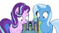 two blue and purple ponies standing next to each other in front of a castle