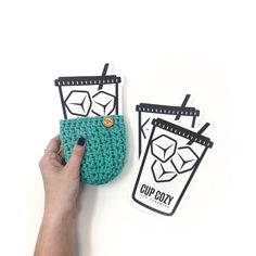 a hand holding a crocheted cup holder next to an iced drink sticker