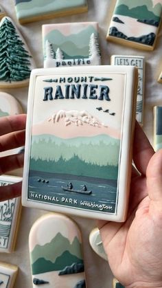 a person holding up some cookies that are decorated with the national park ranger's logo