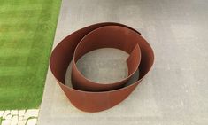 three large brown pots sitting on top of a cement slab next to a green field