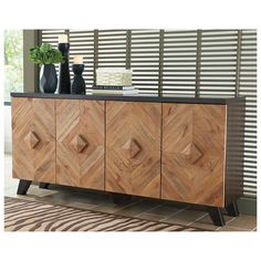 a wooden sideboard sitting on top of a rug