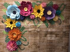 paper flowers are arranged on a wooden surface