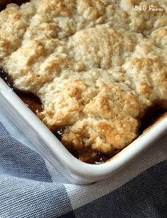 a casserole dish with meat and gravy in it on a blue towel