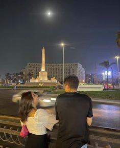 a man and woman are looking at the moon