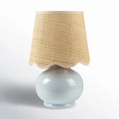 a white table lamp with a beige shade on it's top and bottom half