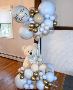 a teddy bear sitting on top of a bunch of balloons