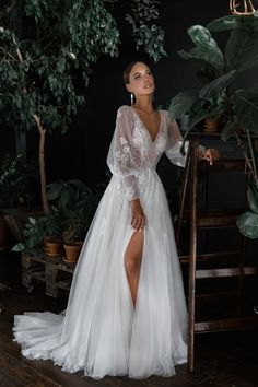 a woman in a white dress standing next to a potted plant and wearing high heels