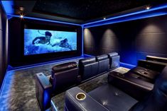 a home theater with leather recliners and blue lighting